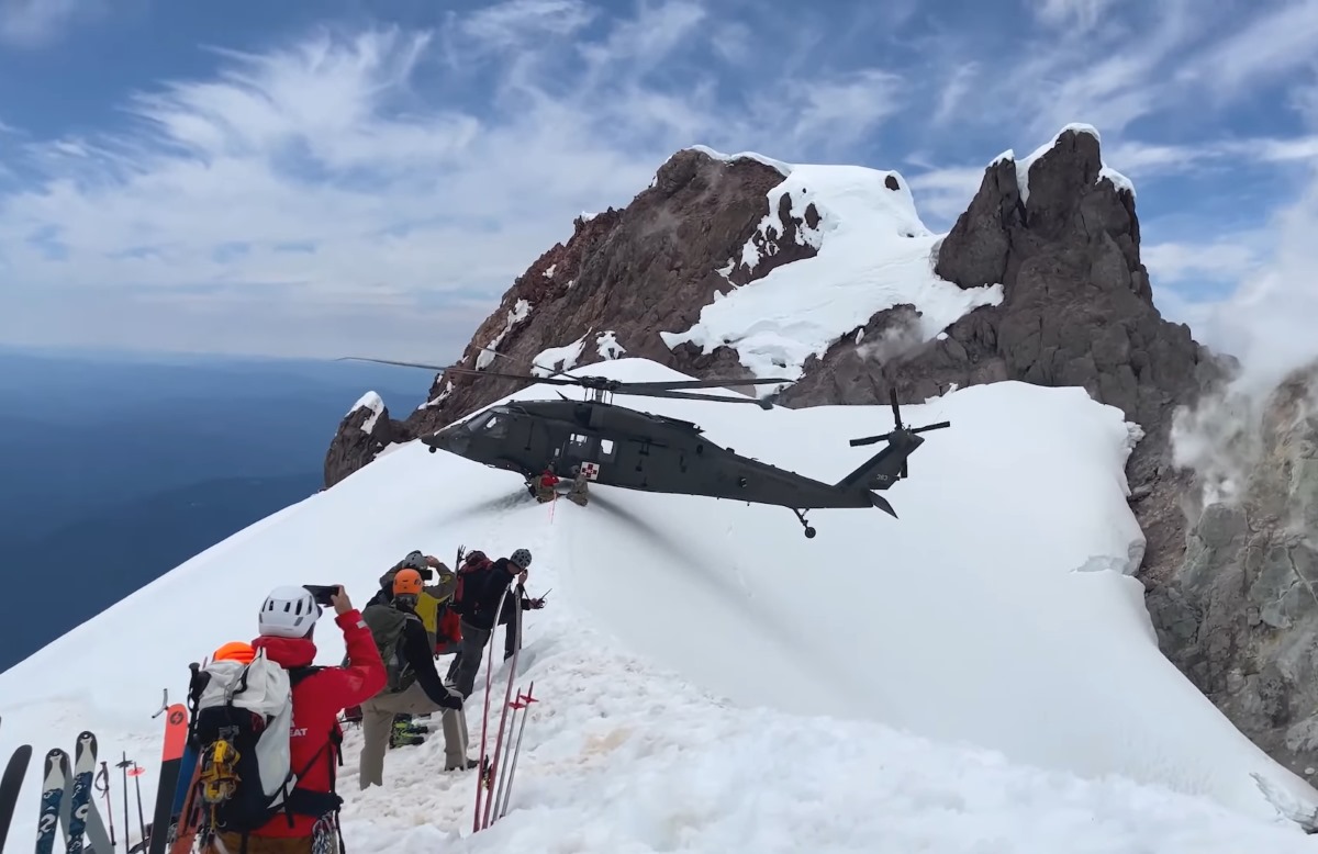 Un helicóptero consigue equilibrarse en la cima de una estrecha montaña para un rescate