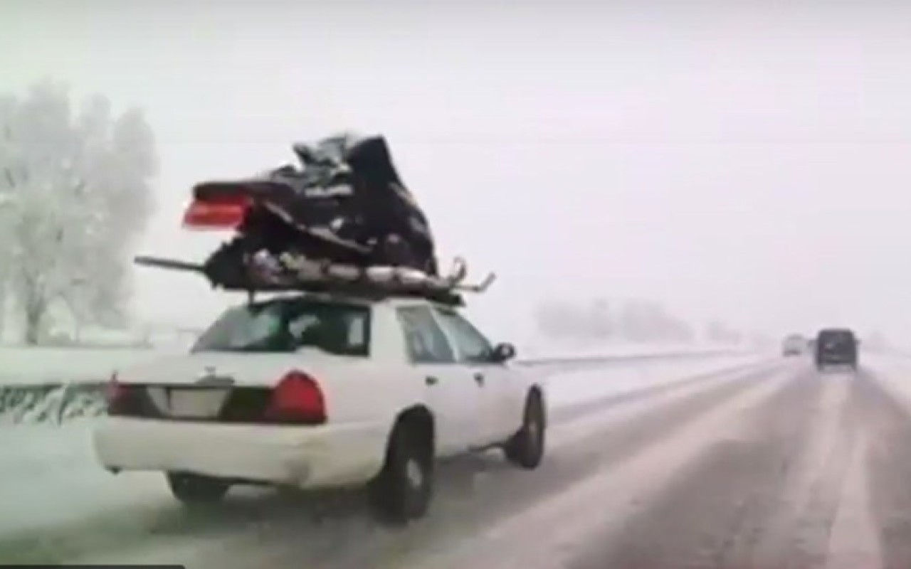 Sorpresa y desconcierto en la carretera por un coche con una moto de nieve atada en el techo