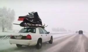 Sorpresa y desconcierto en la carretera por un coche con una moto de nieve atada en el techo