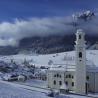 Imagen invernal de Sesto con la iglesia en primer plano, en Dolomitas