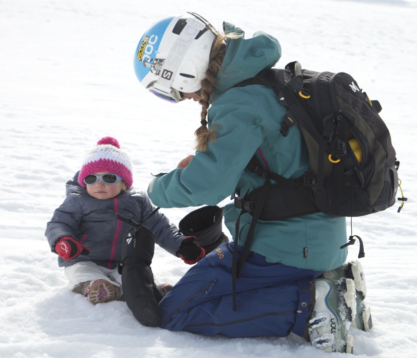 La joven madre y bebé disfruta de vacaciones de esquí en invierno