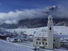 Imagen invernal de Sesto con la iglesia en primer plano, en Dolomitas